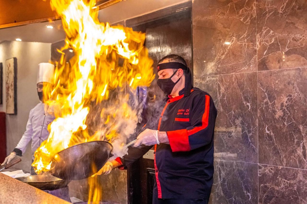 Titanic Beach - Families And Couples Only Hurghada Esterno foto A chef cooking with a wok