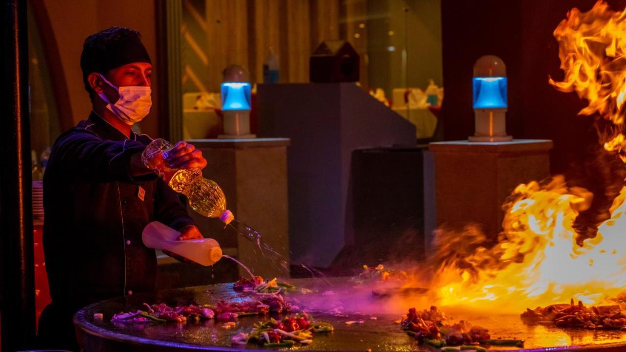 Titanic Beach - Families And Couples Only Hurghada Esterno foto A chef cooking with a flaming torch